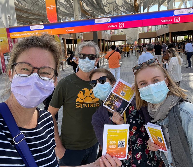Drei Personen des flame-Teams mit Mund-Nasen-Schutz am Eingang der Expo in Dubai
